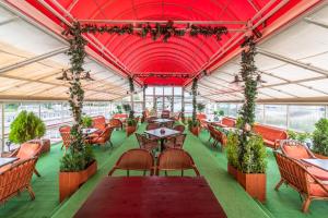 a restaurant with red ceilings and tables and chairs at Botel Albatros in Prague