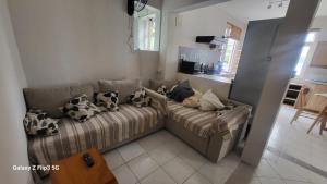 a living room with a couch with pillows on it at Cosey flat Perybere in Grand Baie