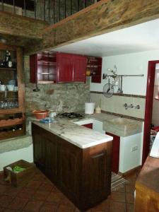 una cucina con mobili rossi e un piano di lavoro di Charming House Óbidos a Óbidos Altre 10 foto