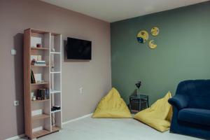 a living room with a blue chair and yellow cushions at Skopje Downtown Hostel in Skopje