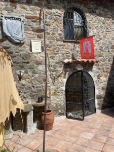 un edificio de piedra con una puerta y un muro de piedra en Un piccolo castello medioevale vicino 5 Terre, en Giucano