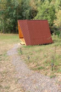 a building with a red roof in a field at Cabana Poiana Florica in Ciucea