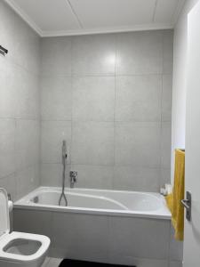 a white bathroom with a tub and a toilet at ventura 250 in Sandton +8 photos