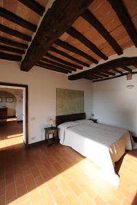a bedroom with a large bed in a room at Fattoria Agriturismo Nerbona in Casole dʼElsa