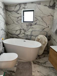 a bathroom with a tub and a toilet and a sink at Larnaca Centre Villa in Larnaka +15 photos