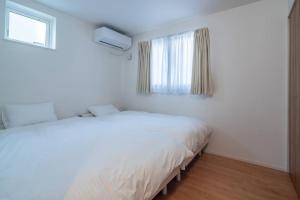 Een bed of bedden in een kamer bij 新屋 札幌中心薄野車程4分鐘 挑高設計客廳 和室空間 可停車2台 高速WiFi 豐平川河岸旁