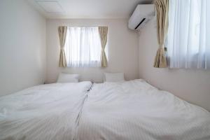 Een bed of bedden in een kamer bij 新屋 札幌中心薄野車程4分鐘 挑高設計客廳 和室空間 可停車2台 高速WiFi 豐平川河岸旁