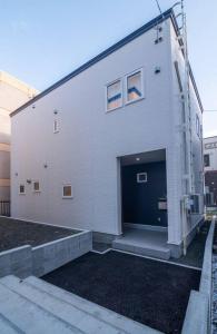 een groot wit gebouw met een grote deur bij 新屋 札幌中心薄野車程4分鐘 挑高設計客廳 和室空間 可停車2台 高速WiFi 豐平川河岸旁 in Toyohira