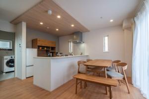een keuken en eetkamer met een tafel en stoelen bij 新屋 札幌中心薄野車程4分鐘 挑高設計客廳 和室空間 可停車2台 高速WiFi 豐平川河岸旁 in Toyohira