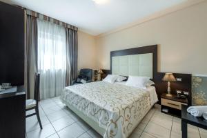 a hotel room with a large bed and a window at Hotel De La Ville Relais in Fiumicino +98 photos