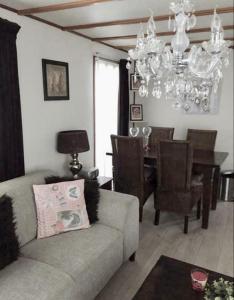 un soggiorno con divano e sala da pranzo di Verzorgd chalet in de Betuwe op park met natuurbad a Beesd