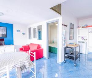 a small room with a bed and a red chair at La Casa di Anna in SantʼAmbrogio