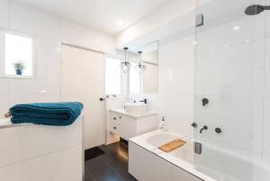 a white bathroom with a sink and a shower at Blairgowrie Beach Townhouse Opposite the beach! in Blairgowrie +36 photos