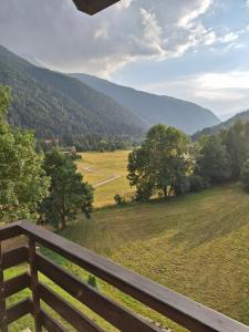 a bench with a view of a field and mountains at Grande casa di famiglia in Temù