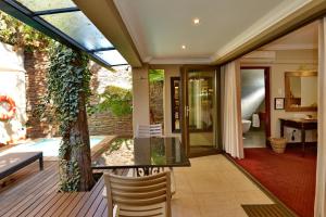 a conservatory with a table and chairs on a deck at The Residence in Johannesburg