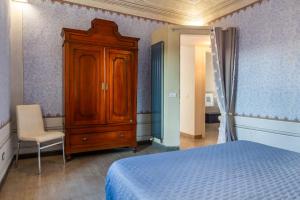 a bedroom with a bed and a cabinet and a chair at Ampio appartamento di Charme con 2 camere, 2 bagni, terrazza, aria condizionata, in posizione Centralissima in Cecina