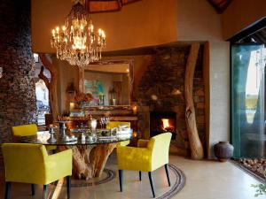 a dining room with a table and chairs and a fireplace at Molori Safari in Derdepoort
