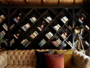a room with a couch and a wall of books at Molori Safari in Derdepoort