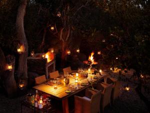a long wooden table with candles and lights on it at Molori Safari in Derdepoort