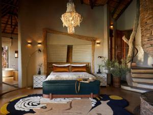 a bedroom with a bed and a chandelier at Molori Safari in Derdepoort +27 photos