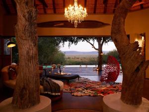 a living room with trees and a chandelier at Molori Safari in Derdepoort