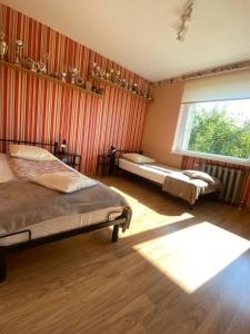 a bedroom with two beds and a large window at Private house in Valmiera