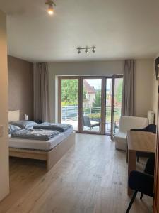 a bedroom with a bed and a sliding glass door at Modernes & gepflegtes Hotelzimmer mit Küche! in Bernstadt +12 photos