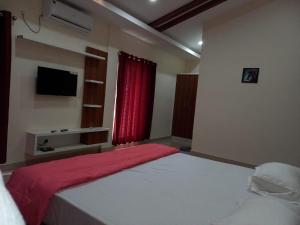 a bedroom with a large bed with a red curtain at Whiteflower Mountain Resort in Perintalmanna