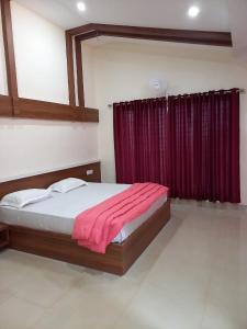 a bedroom with a bed with a red curtain at Whiteflower Mountain Resort in Perintalmanna