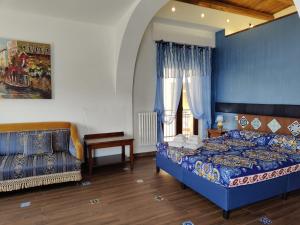 a bedroom with a blue bed and a window at Centro Sicilia Rooms & Suites in Enna
