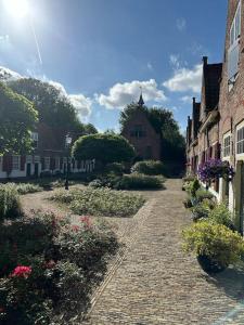 a cobblestone street in a town with houses and flowers at Authentiek Verblijf in het Hart van het Westland in Naaldwijk