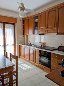 a kitchen with wooden cabinets and a stove top oven at Da Nonna Gina - in centro con parcheggio gratuito in Paestum