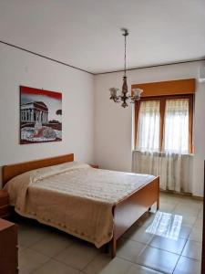 a bedroom with a large bed and a window at Da Nonna Gina - in centro con parcheggio gratuito in Paestum
