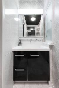 ein Badezimmer mit Waschbecken und Spiegel in der Unterkunft The Exeparel in Kushiro + 53 Fotos