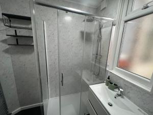 a bathroom with a glass shower and a sink at Spacious Home - Sleeps 5 persons - Minutes Walk from Anfield Stadium in Liverpool