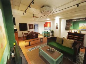 un soggiorno con un divano verde e un tavolo di 57 Ruma Oren Heritage Jonker Residence Melaka a Malacca