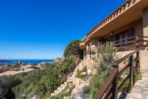 a house on a hill with the ocean in the background at Villetta Panoramica Costa Paradiso in Costa Paradiso