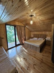 a bedroom with two beds in a wooden room at Iveria Parky and cottages in Shekhvetili +165 photos