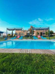 a large swimming pool with blue water in a yard at Le Jardin d'Emilie TINY in Menetou-Râtel