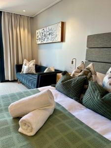 a hotel room with a bed with pillows on it at Modern 14th floor Apt with Balcony & Mountain Views at 16onBree in Cape Town +11 photos