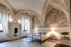 Un dormitorio grande con una pared de ladrillo y una cama en Calzaiuoli Apartments by Mamo Florence, en Florencia