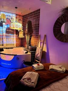a bedroom with a tub and a bed with towels on it at Suite Marrakech - Rennes centre in Rennes