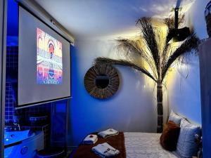 a blue room with a bed and a palm tree at Suite Marrakech - Rennes centre in Rennes