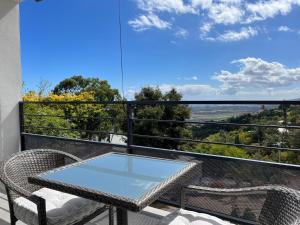a table and chairs on a balcony with a view at Studio vue mer & montagne à Bellemène - Calme et confort in Saint-Paul