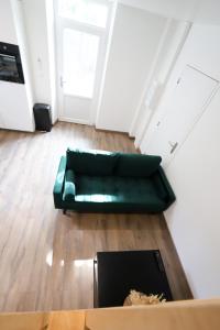 un soggiorno con un divano verde e un tavolo di Maison au calme, proche gare & centre-ville a Brive-la-Gaillarde