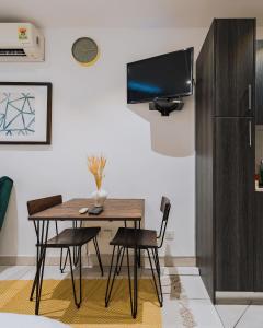 The Avery Studio at Embassy Gardens, Cantonments في آكرا: غرفة طعام مع طاولة وكراسي وتلفزيون