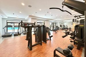 einen Fitnessraum mit mehreren Laufbändern und Heimtrainern in der Unterkunft 1bd Partial Burj Al Arab View Prime Location in Dubai