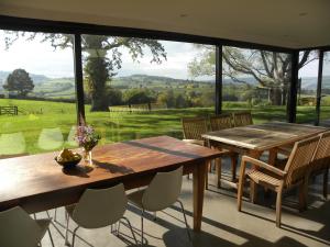 a dining room with a table and chairs and a large window at Penylan Barn in Hay-on-Wye