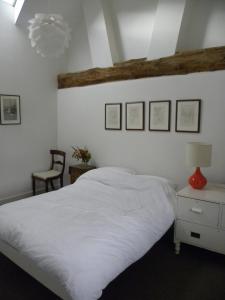 a bedroom with a white bed with a red lamp and a chair at Penylan Barn in Hay-on-Wye