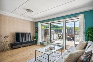 a living room with a couch and a tv at child friendly 4 room apartment in Kolsås